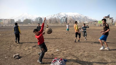 Afghan youths play football next to the Ghazi stadium in Kabul on February 15, 2014. AFP