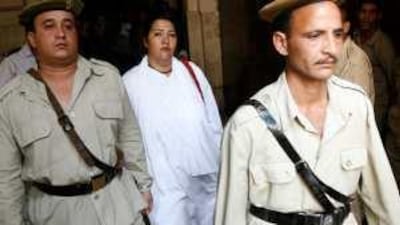 Iris Botros, a US citizen of Egyptian origin accused of trying to illegally adopt Egyptian children, is escorted into court in Cairo on Thursday.