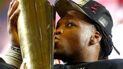 Derrick Henry #2 of the Alabama Crimson Tide celebrates by kissing the College Football Playoff National Championship Trophy after defeating the Clemson Tigers in the 2016 College Football Playoff National Championship Game at University of Phoenix Stadium on January 11, 2016 in Glendale, Arizona. The Crimson Tide defeated the Tigers with a score of 45 to 40. Christian Petersen/Getty Images/AFP