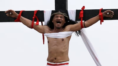 Ruben Enaje grimaces after gets nailed to the cross for the 32nd year in a row during a re-enactment of Jesus Christ's sufferings as part of Good Friday rituals in the village of San Pedro Cutud, Pampanga province, northern Philippines. Aaron Favila / AP Photo