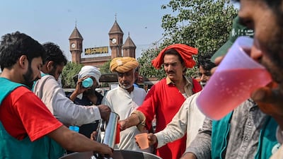 Volunteers distribute cold drinks to bypassers at a 'heatwave relief camp' along the road during a hot summer day in Lahore in May. AFP