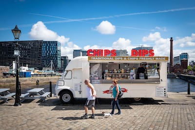 Pedestrians walk by a food truck between The Pier Head and Albert Dock. Darren Robinson for The National