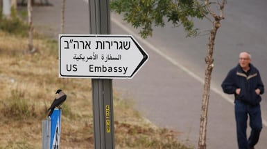A man walks next to a road sign directing to the US embassy, in the area of the US consulate in Jerusalem. Reuters