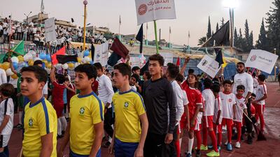 Excited children take part in the opening ceremony at the municipal stadium in Idlib, north-west Syria, wearing the jerseys of this year's World Cup teams