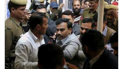 India's former telecommunications minister, Andimuthu Raja, centre, is produced at a court in New Delhi, India, yesterday. Federal agents arrested Mr Raja and two other officials on Wednesday in an investigation into a scandal that allegedly cost the government billions of dollars.