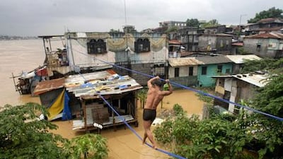A Filipino man walks on a rope line to a rooftop in Pasig City, eastern Manila.
