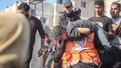 A first responder, running the gauntlet of Israeli fire, carries an injured child to safety after an air strike in a refugee camp near Khan Younis, Gaza. Bloomberg
