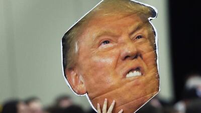 A man holds a photo of Republican presidential candidate Donald Trump before a rally in Louisville, Kentucky. John Bazemore / AP Photo