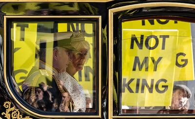 Britain's King Charles III and Queen Camilla travel past anti-monarchy protesters in London on Tuesday. In May this year, a woman was detained by police for 13 hours after finding herself standing too close to a demonstration during King Charles's coronation. Reuters