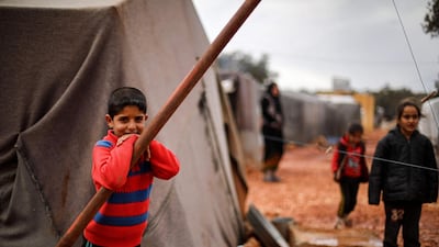 A boy looks on as he stands outside a tent at a flooded camp for displaced Syrians near the village of Killi in the north of the northwestern Idlib province. AFP
