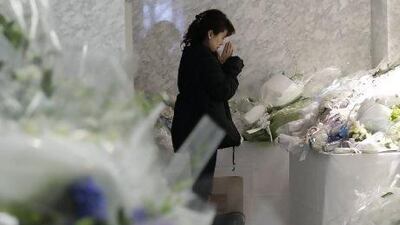 A woman prays near bouquets left at the company’s Yokohama headquarters to honour the Japanese employees of JGC Corporation who died in the standoff at the Ain Amenas gas plant in Algeria.