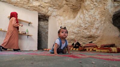 Ahmed Amarneh's daughter crawls across the carpeted floor of his home in a cave. AFP