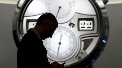 A man cheks his cellphone next to the stand of German watchmaker A Lange & Soehne. Fabrice Coffrini / AFP