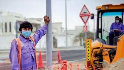 Road workers on a chilly and hazy morning in Khalifa City in Abu Dhabi. Victor Besa / The National