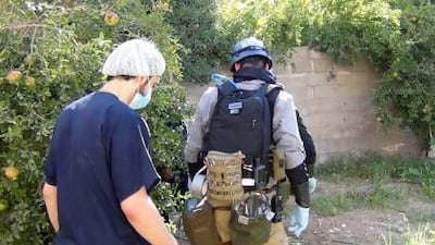 A UN chemical weapons expert (right) gathers evidence at one of the sites of an alleged poisonous gas attack in the southwestern Damascus suburb of Mouadamiya.