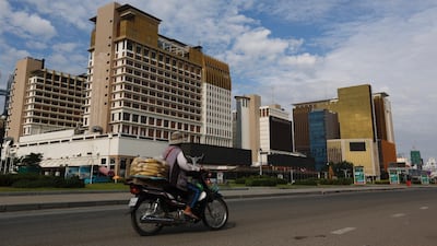 A Cambodian vendor rides a motorbike past the Nagaworld Casino in Phnom Penh, Cambodia. EPA