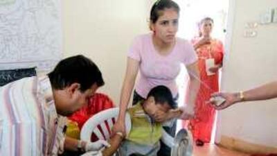 A healthcare worker draws blood from a young boy to test for the virus hepatitis C at a clinic in Cairo.