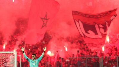 Ahly's Egyptian goalkeeper Mohamed el-Shenawy reacts to the smoke and flares. AFP