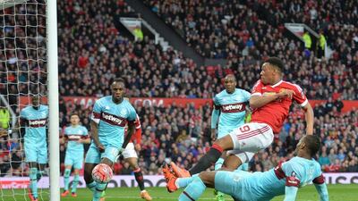 Manchester United’s French striker Anthony Martial (2nd R) gets in front of West Ham United’s Senegalese striker Diafra Sakho (R) to score their first goal during the English FA Cup quarter final football match between Manchester United and West Ham United at Old Trafford in Manchester, north-west England, on March 13, 2016. The game ended 1-1. AFP / PAUL ELLIS