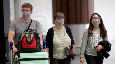 Passengers arriving on flights wear protective masks at the international airport in Auckland, New Zealand. Getty Images