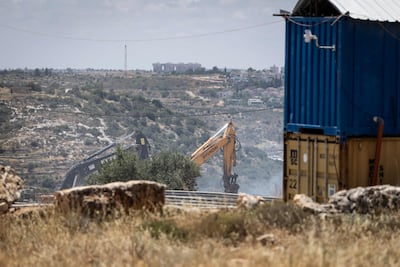 Israeli earthmovers demolish a building next to a factory in the occupied West Bank. AFP