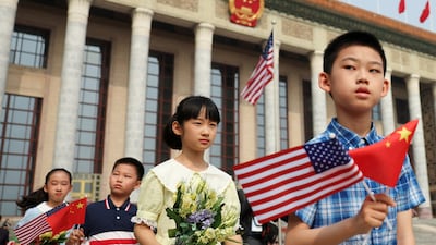 Children hold Chinese and US flags before the welcome ceremony at the Great Hall of the People. Reuters
