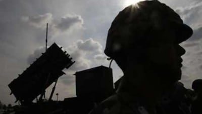 A member of Japan's Self-Defence Forces stands next to a Patriot Missile System at an exhibition during the Security and Safety Trade Expo in Tokyo.