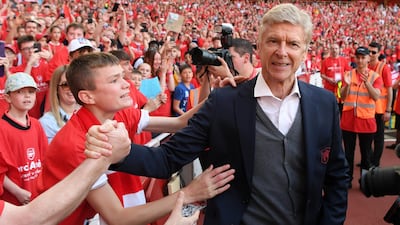 Arsene Wenger shakes hands with an Arsenal fan. Mike Hewitt / Getty Images