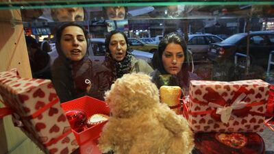 Iranian women look at Valentine's Day gifts on display in a shop window in Tehran on February 13, 2012. AFP PHOTO/ATTA KENARE