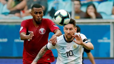 Argentina's Lionel Messi vies for the ball with Qatar's Abdelaziz Mohamed. EPA