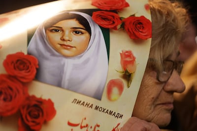 A protester holds a photograph of a young girl reported killed in the bombing of a primary school in Minab, Iran, during a solidarity rally in Serbia. EPA