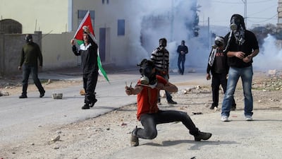 Palestinian protesters throw stones during clashes over the Jewish settlement of Qadomem, near Nablus. Alaa Badarneh / EPA
