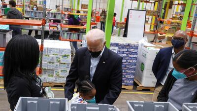 US President Joe Biden hugs a child as he visits the Houston Food Bank in Houston, Texas. Reuters