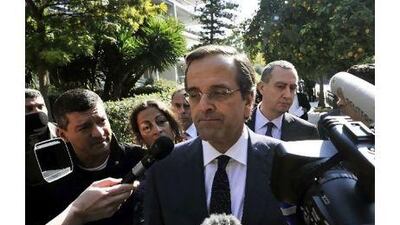 The leader of the main Greek opposition party, Antonis Samaras, centre, talks to reporters after his meeting with Greece's president in Athens yesterday.