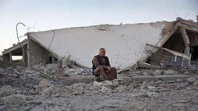 A man sits in a site damaged by what activists said were barrel bombs dropped by forces loyal to Syria's president Bashar Al Assad in the historic southern town of Bosra Al Sham on October 21, 2015. Alaa Al Faqir/Reuters