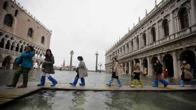 People use trestle bridges to walk in a flooded St. Mark's Square at Venice. AP Photo
