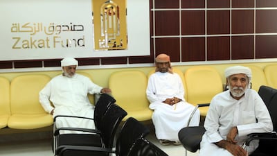Men wait to collect Zakat donated by the public and distributed by the Zakat Fund in Abu Dhabi. The National