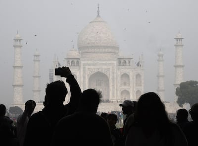 Visitors take photos in front of the Taj Mahal in Agra. AFP