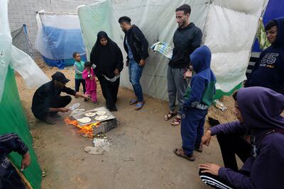 Palestinians displaced by the Israeli bombardment of Gaza cook near Al Aqsa Hospital in Deir Al Balah. AP Photo