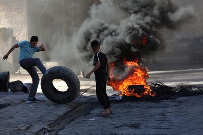People burn tires before the funeral of Osama Sobh, 22, killed overnight in an Israeli military raid at Burqin village, near the West Bank city of Jenin on September 26. EPA