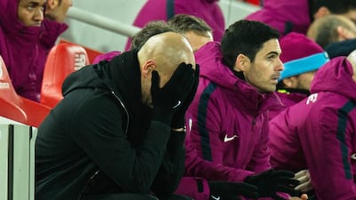 Manchester City manager Pep Guardiola, left, holds his head in his hands after seeing Liverpool take a 4-1 lead at Anfield. Despite a late rally, City would lose the match 4-3. Peter Powell / EPA
