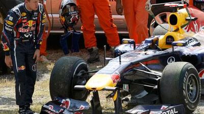 Sebastian Vettel inspects the damage he wrought on his Red Bull Racing car after crashing in the first practice session for the Japanese Grand Prix.