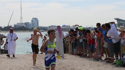 A young boy runs after completing his swim.