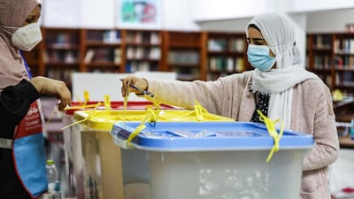 A mask-clad voter casts her ballot while voting in an election for the Tripoli Municipal Council, in Libya's capital on February 6, 2021. AFP
