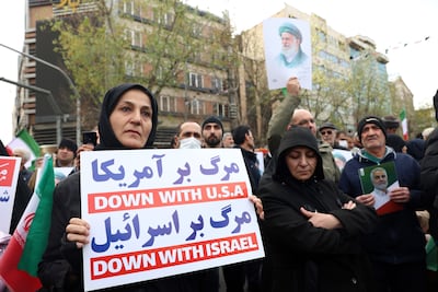 Mourners hold anti-US and anti-Israeli placards during a funeral ceremony this week for security personnel killed in Tehran. EPA