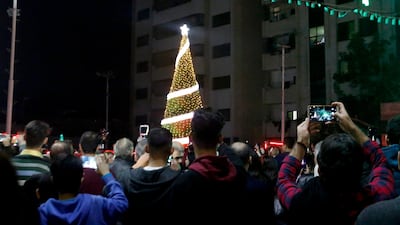 Palestinians record the Christmas tree lighting in Gaza City. AP Photo