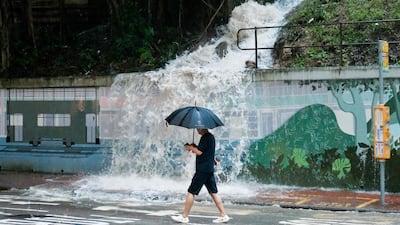 Water from an overflowing drain spills onto a street in the Quarry Bay area of Hong Kong during a storm warning. AFP