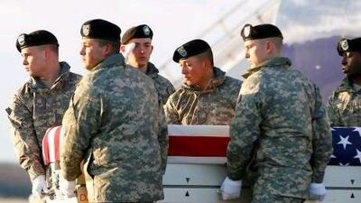 A US Army carry team carries the transfer case containing the remains of Sergeant Joshua Born of Niceville, Florida, upon arrival at Dover Air Force Base in Delaware on Saturday. The 25-year-old was shot dead by an Afghan soldier during a riot on Thursday over the burning of Qurans.