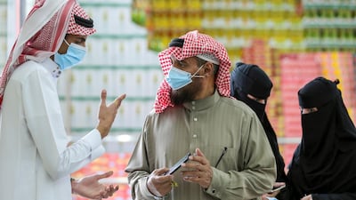 A man shows his details using the Tawakkalna app on his mobile phone as he enters the Al Othaim market in Riyadh. Reuters
