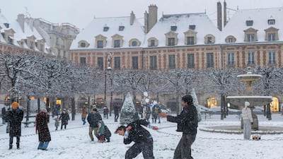 Youngsters play with in the snow on the Place des Vosges in Paris. AFP